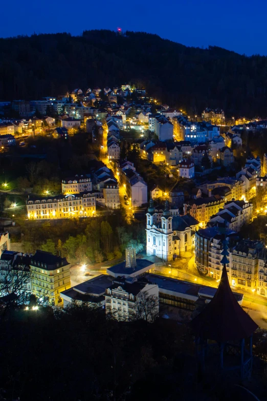 a view of a town lit up at night, inspired by Karl Stauffer-Bern, epic lighting from above, liege, yellow, top