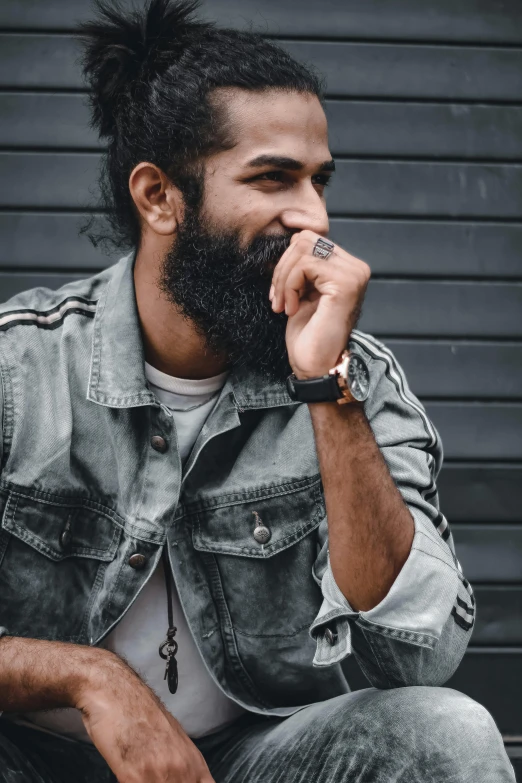 a man with a beard sitting on a bench, trending on pexels, hurufiyya, with textured hair and skin, wearing a watch, profile image, indian