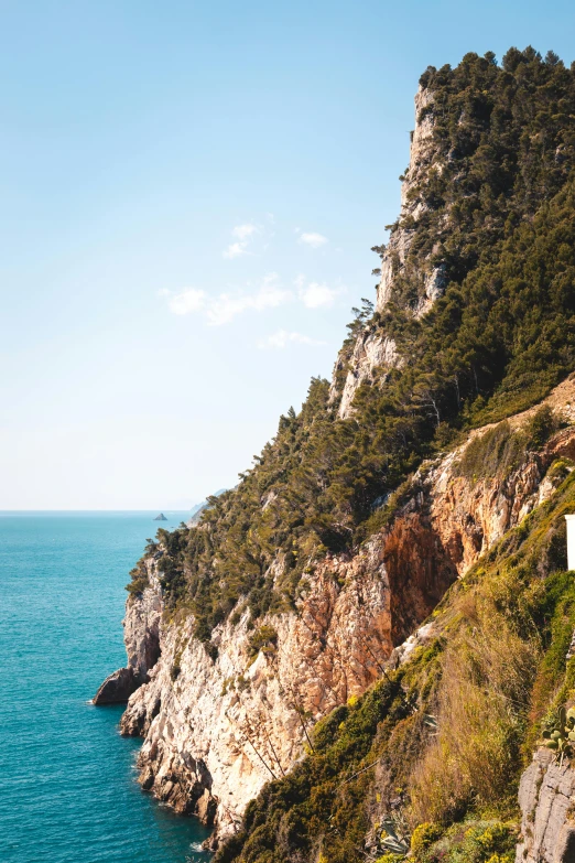 a train traveling along the side of a mountain next to the ocean, cannes, capri coast, manly, no crop