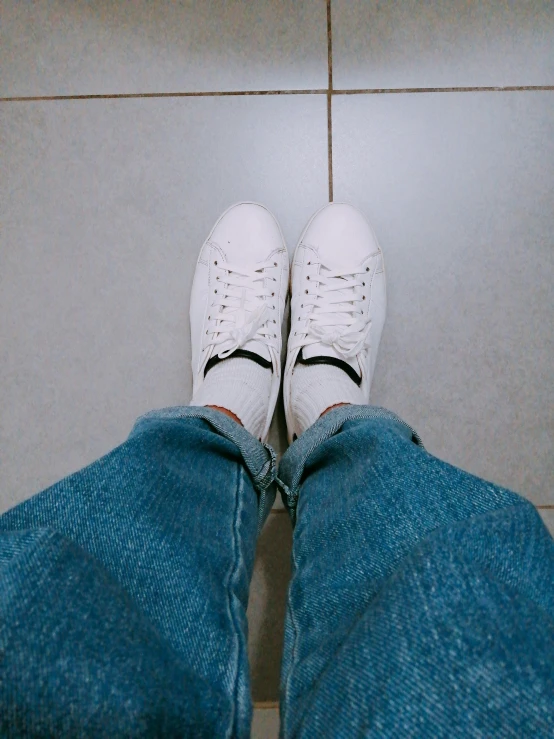 the legs of a person standing on a tiled floor, by Robbie Trevino, wearing white sneakers, highly detailed # no filter, 🤠 using a 🖥, white soft leather model