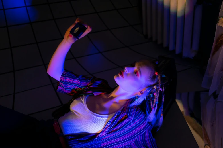 a woman is playing a video game in the dark, a hologram, inspired by Elsa Bleda, unsplash contest winner, lying down, solar punk product photo, portrait top light, shot with sony alpha 1 camera