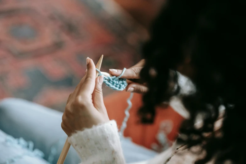 a woman knitting while sitting on a couch, trending on pexels, avatar image, blue soft details, crafts, professional image