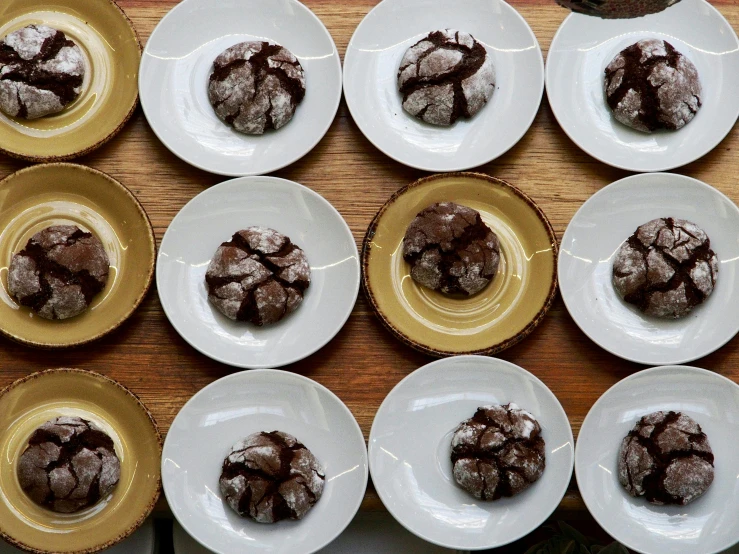 a wooden table topped with white plates filled with cookies, inspired by Richmond Barthé, unsplash, large cracks, fully chocolate, thumbnail, epicurious