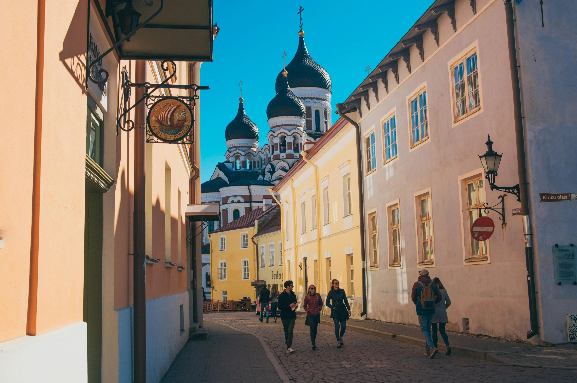 a group of people walking down a street, by Julia Pishtar, pexels contest winner, baroque, capital of estonia, domes, colorful scene, high quality upload