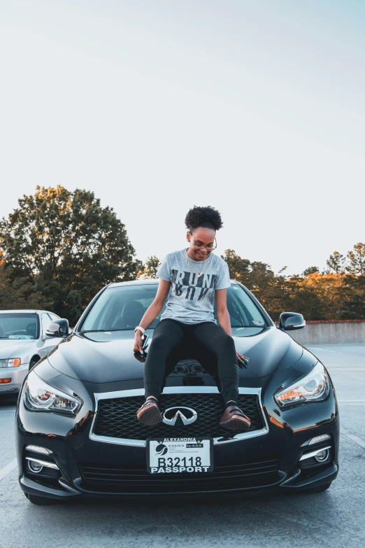 a man sitting on top of a car in a parking lot, photo of a black woman, with infinity, popular on instagram, profile image