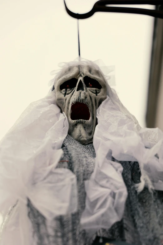 a skeleton hanging from a pair of scissors, a statue, unsplash, closeup. mouth open, funeral veil, gray alien, 1/60