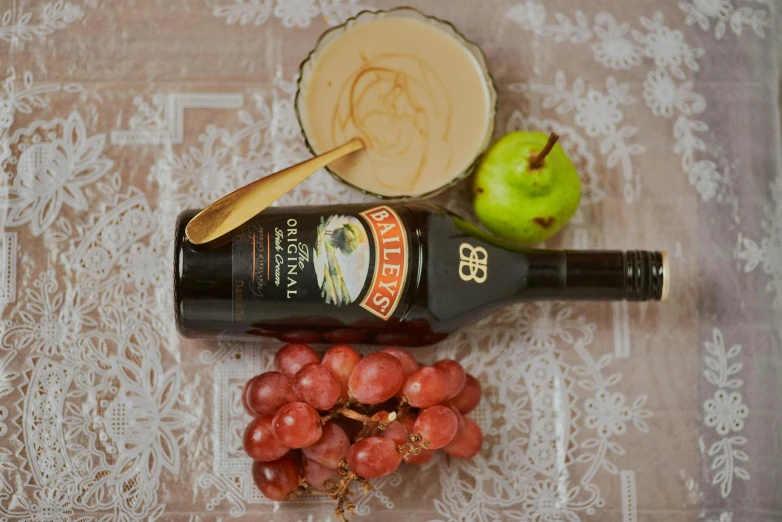 a bottle of wine sitting on top of a table, a still life, inspired by Charles Le Roux, pexels contest winner, brown gravy, mayo, fruit, high angle close up shot