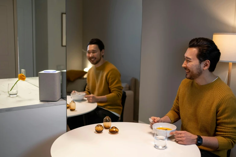 a man sitting at a table with a cup of coffee, a hologram, happening, two buddies sitting in a room, sony a 7 siii, smiling at each other, shot on alexa