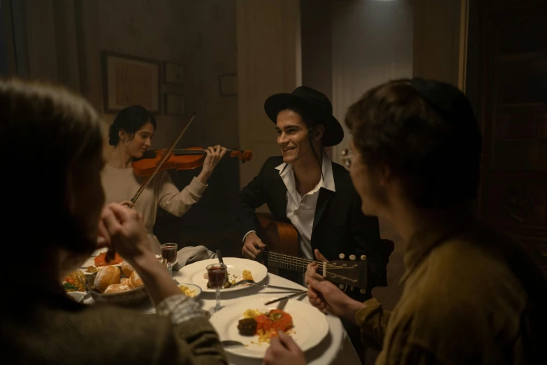 a group of people sitting around a dinner table, women playing guitar, costumes from peaky blinders, nick alm, [ theatrical ]