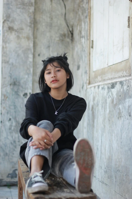 a woman sitting on top of a wooden bench, inspired by Ruth Jên, pexels contest winner, sumatraism, casual black clothing, ((portrait)), tomboy, leaning against the wall