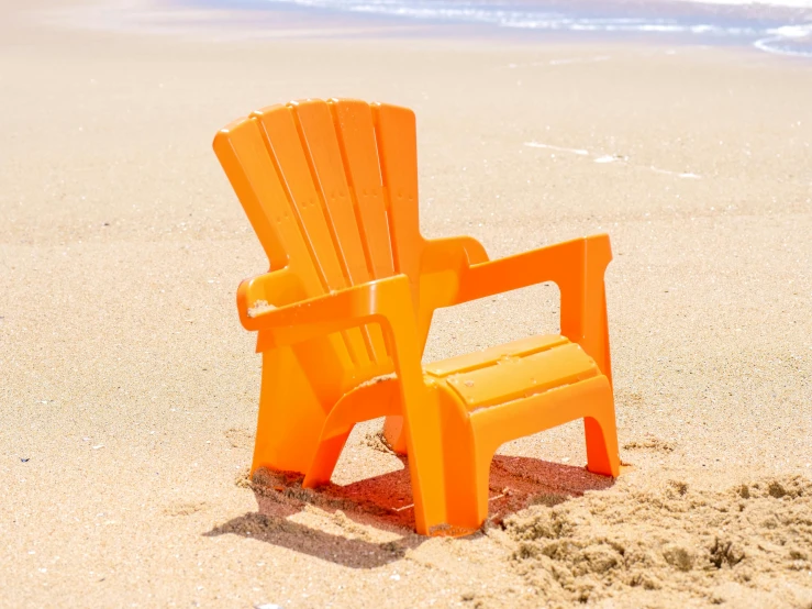 an orange plastic chair sitting on top of a sandy beach, sitting on a table, little kid, 3 d print, chill out