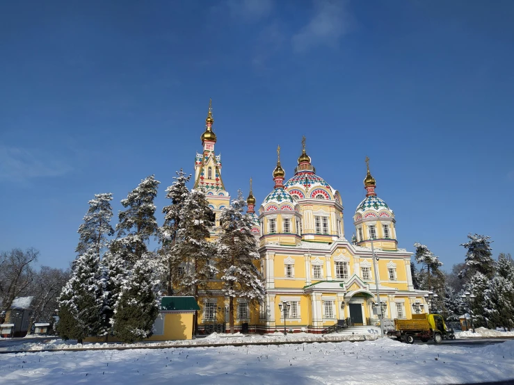 a large yellow building sitting on top of a snow covered field, a photo, inspired by Ivan Bilibin, art nouveau, lead - covered spire, pink, located in hajibektash complex, фото девушка курит