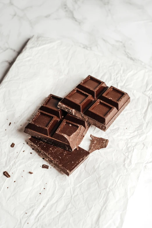 a piece of chocolate sitting on top of a piece of paper, squares, organic, 6 pack, uncrop