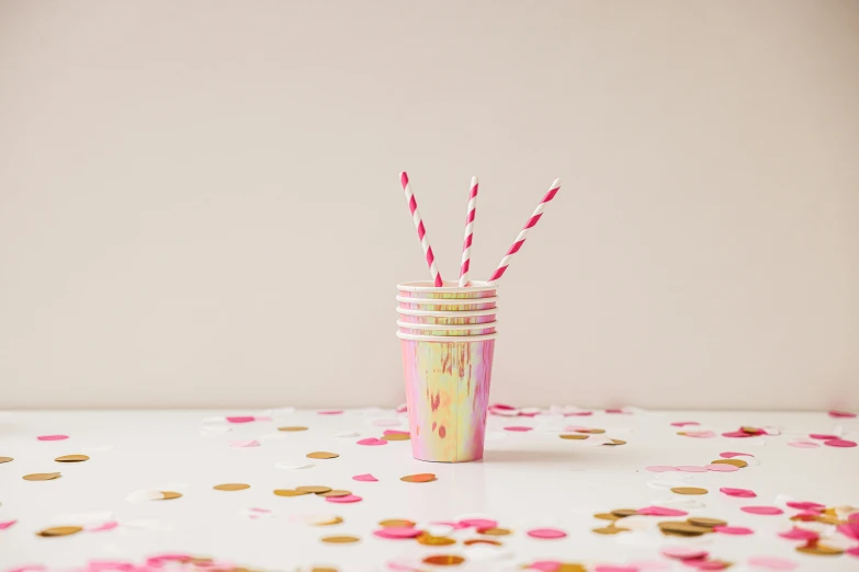 a close up of a cup with two straws in it, an album cover, by Rachel Reckitt, unsplash, pink and gold, marbled, birthday party, paper cup