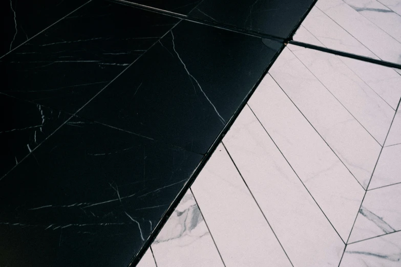 a white toilet sitting on top of a black tiled floor, a black and white photo, unsplash, postminimalism, pink marble building, glassy fracture, split in half, made of liquid metal and marble