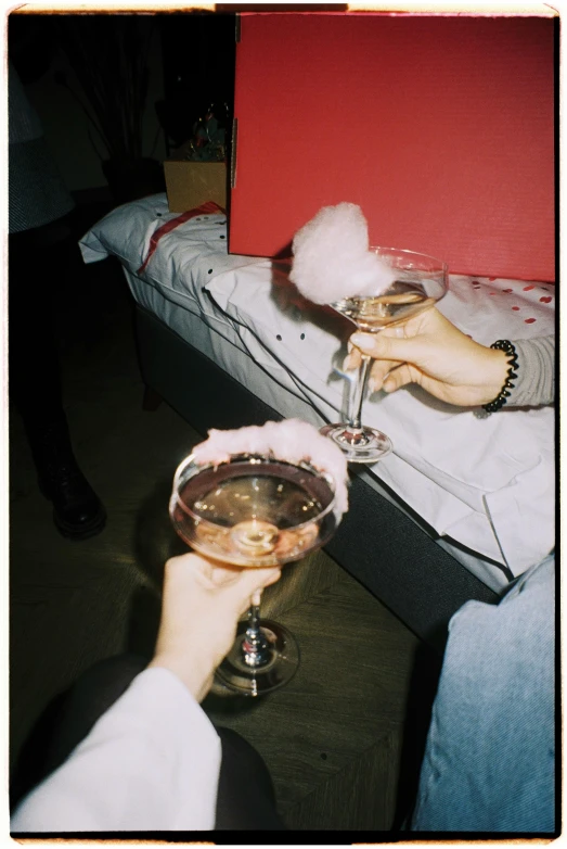 a close up of a person holding a glass of wine, a polaroid photo, inspired by Nan Goldin, pop art, made of cotton candy, champagne on the table, 1997 ), many partygoers