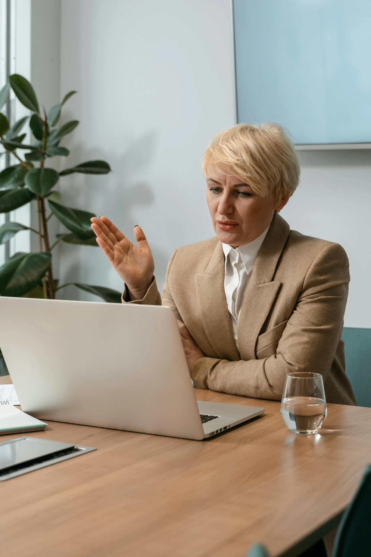 a woman sitting at a table in front of a laptop, convincing, professional grade, a blond, high drama