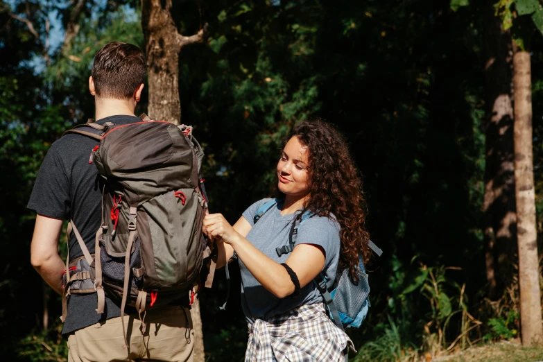 a woman standing next to a man with a backpack, by Meredith Dillman, pexels contest winner, happening, letterboxing, avatar image, lachlan bailey, flirting