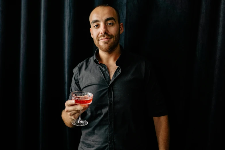 a man in a black shirt holding a wine glass, a portrait, inspired by Matteo Pérez, pexels contest winner, cocktail bar, mid body portrait, medium head to shoulder shot, around 20 yo