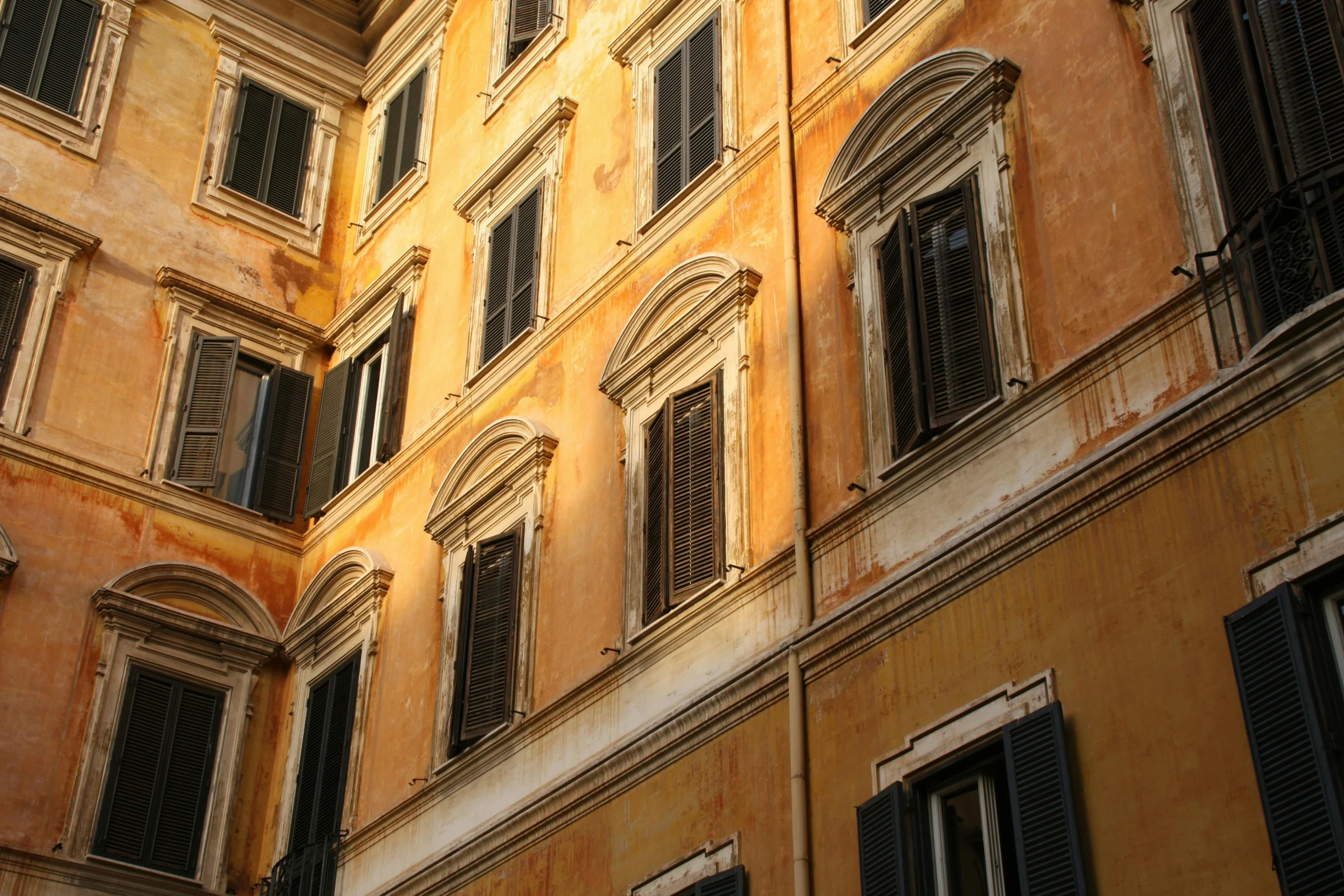 a very tall building with lots of windows, inspired by Michelangelo Buonarotti, pexels contest winner, neoclassicism, light - brown wall, yellows and reddish black, shady alleys, profile image