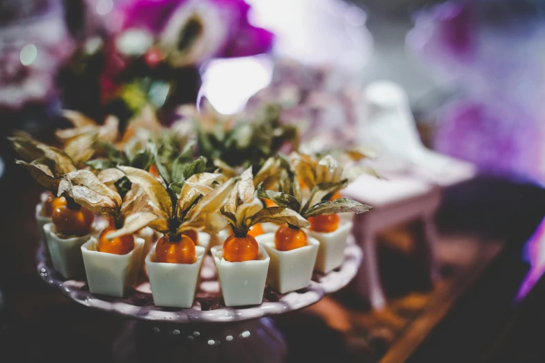 a close up of a plate of food on a table, a tilt shift photo, by Lucia Peka, unsplash, art nouveau, candy decorations, bromeliads, white and purple, cups and balls