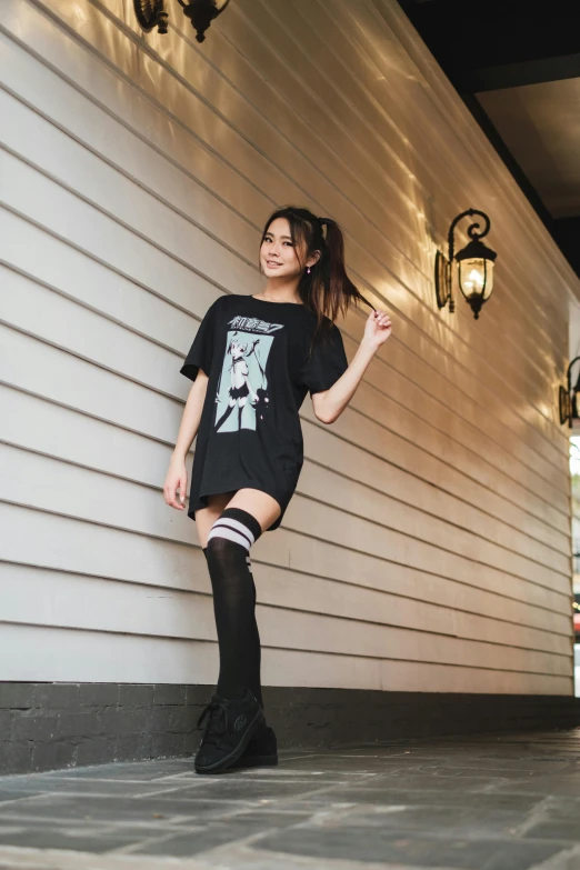 a woman standing in front of a white wall, a cartoon, by Sengai, unsplash, shin hanga, wearing a black!! t - shirt, wearing kneesocks, playboy style, mall goth