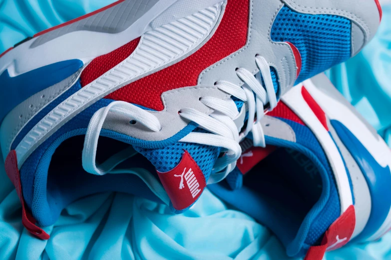 a close up of a pair of shoes on a bed, by Matija Jama, unsplash contest winner, brand colours are red and blue, puma, silver white red details, animation
