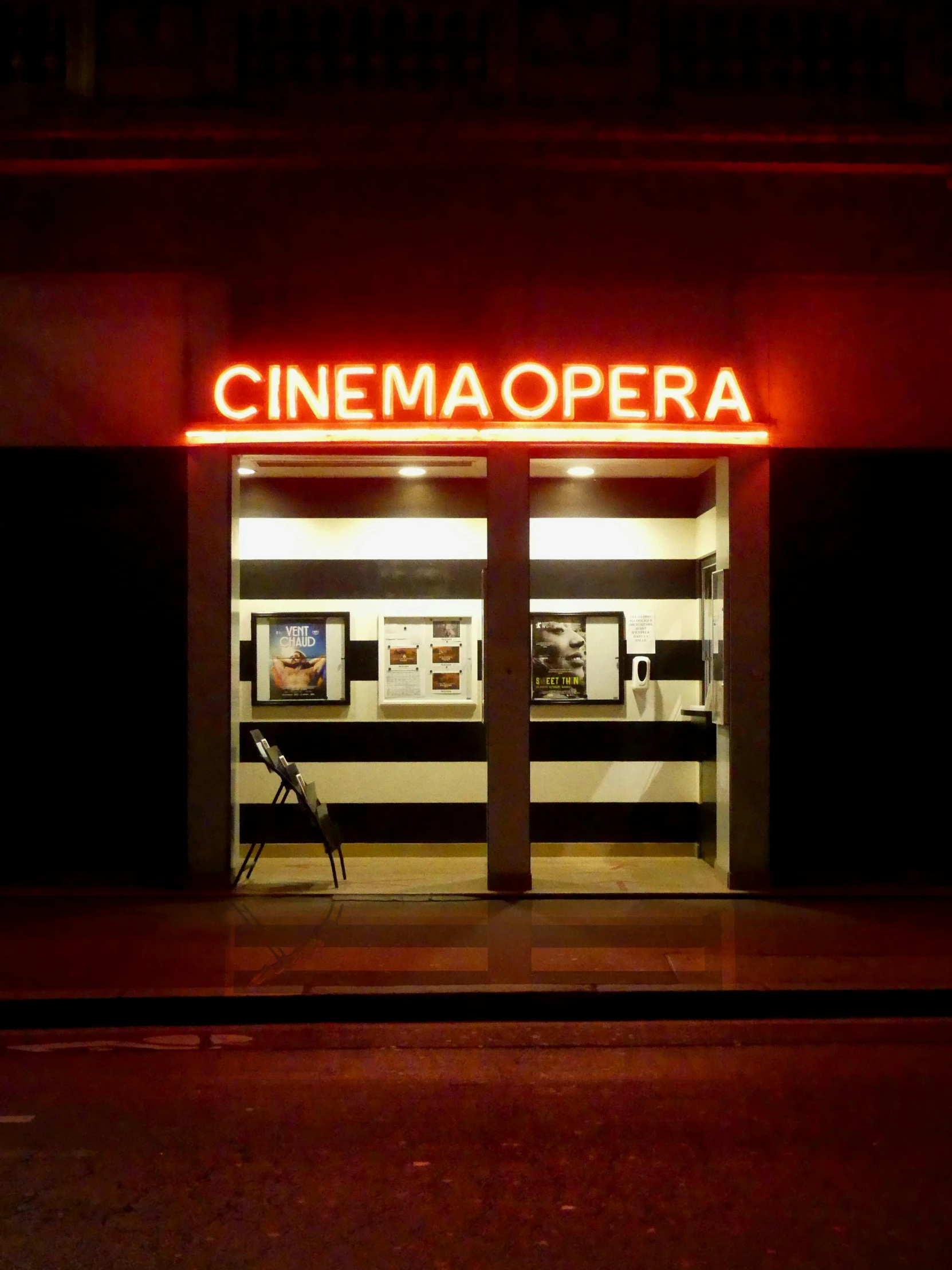 a cinema theater is lit up at night, by Emma Andijewska, instagram, hyperrealism, profile image, cinematic. ”, opera, photo for a store