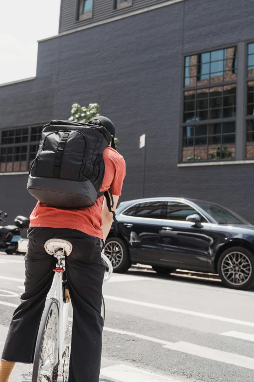 a person riding a bike on a city street, a man wearing a backpack, black on black, thumbnail, detailing