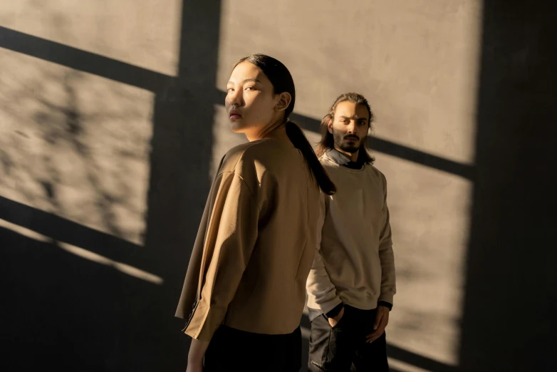 a man and a woman standing next to each other, a portrait, inspired by Wang Duo, pexels contest winner, brown clothes, shadows on side, official store photo, ayanamikodon and irakli nadar