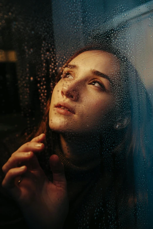 a woman looking out a window in the rain, a picture, trending on pexels, magical realism, portrait of depressed teen, light falling on face, girl with brown hair, sad man