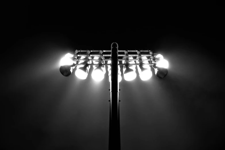 a black and white photo of a street light, conceptual art, dramatic stadium lighting, top down spotlight lighting, many glowing lights, led lighting effects