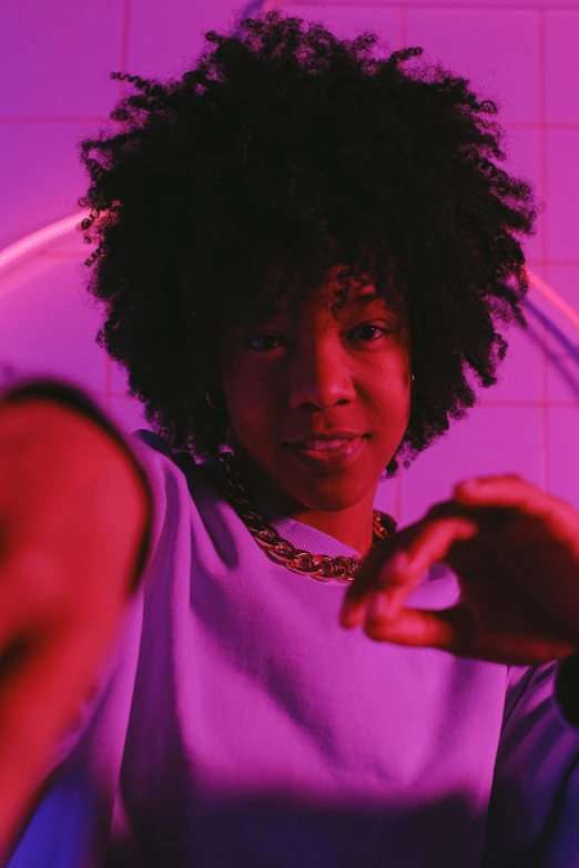 a woman sitting in a chair in front of a mirror, an album cover, trending on pexels, graffiti, ((purple)), black teenage boy, curly afro, triumphant pose