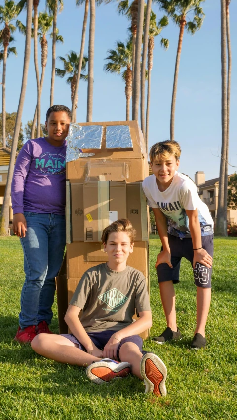 a group of people sitting on top of a lush green field, robot made of a cardboard box, sun coast, standing outside a house, profile image