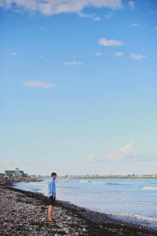 a person standing on a beach flying a kite, clear blue skies, jerez, cute boys, bedhead