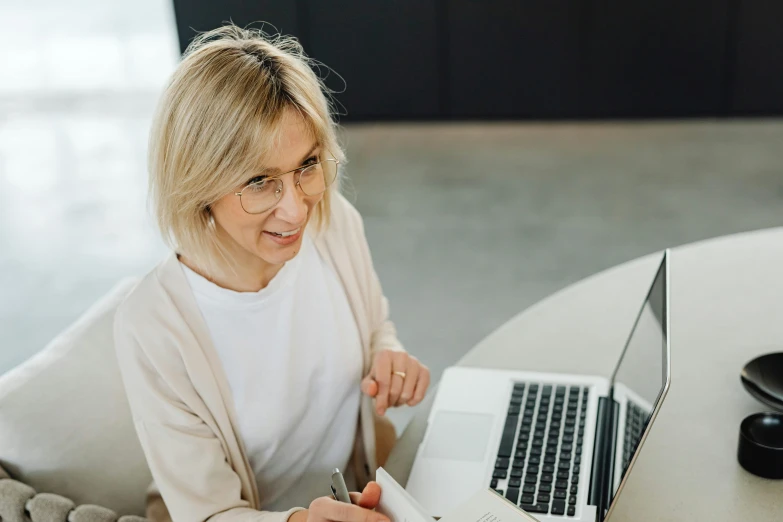 a woman sitting at a table with a laptop, pexels contest winner, a blond, school curriculum expert, award-winning style, people at work