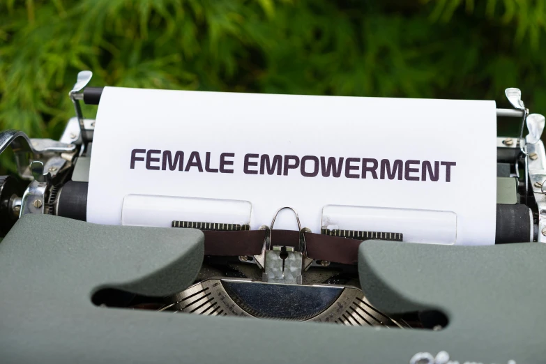 a close up of a typewriter with a paper on it, feminist art, superpowers, feminine figure, environmental shot, view from the ground