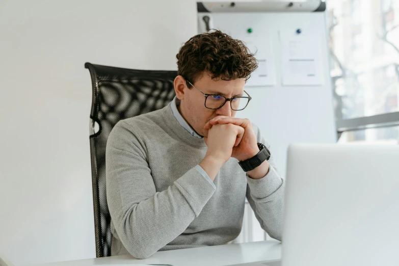 a man sitting at a desk in front of a laptop computer, pexels, lachlan bailey, hunched shoulders, man with glasses, thumbnail