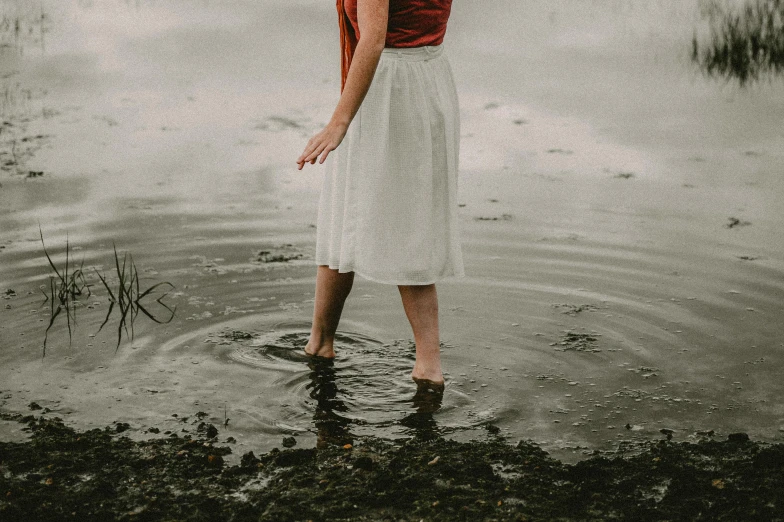 a woman standing in the water holding an umbrella, white shirt and grey skirt, francesca woodman style, red water, about to step on you