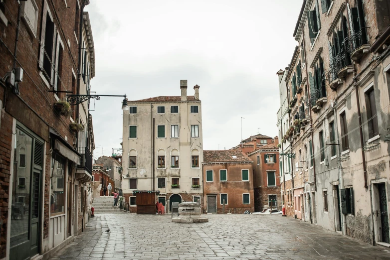 a cobblestone street with buildings in the background, inspired by Quirizio di Giovanni da Murano, pexels contest winner, arte povera, square, white pale concrete city, venetian red, 2022 photograph