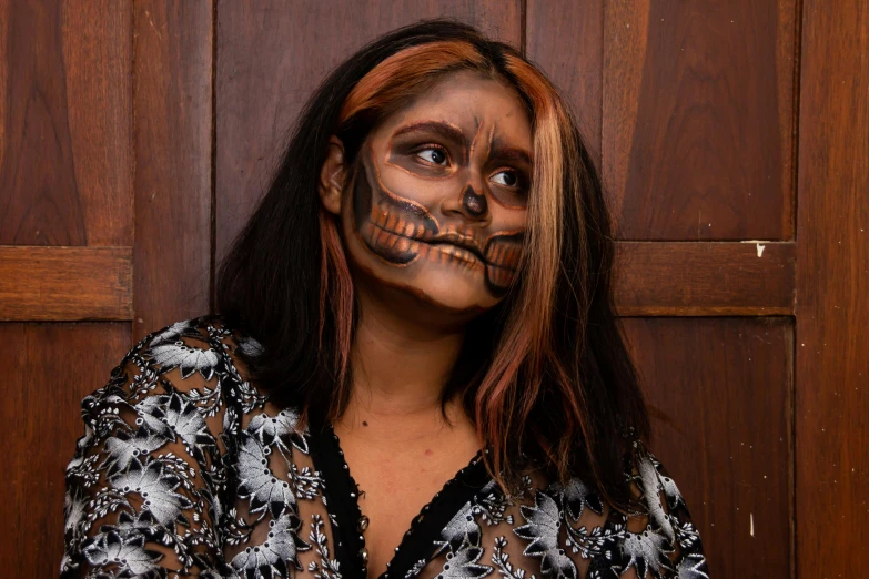 a woman with a skeleton face painted on her face, pexels contest winner, lowbrow, tanned ameera al taweel, bronze skinned, full body image, brown