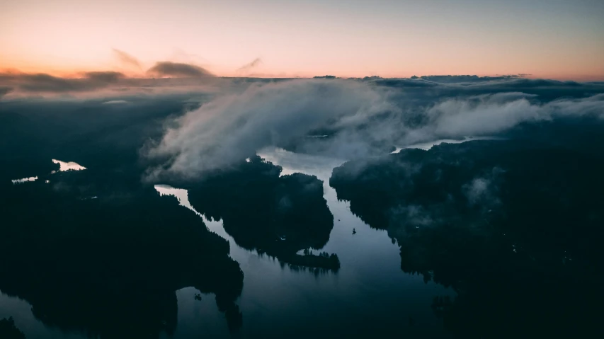 a large body of water sitting on top of a lush green hillside, by Sebastian Spreng, pexels contest winner, hurufiyya, foggy sunset, flying islands, aerial view from above, overcast lake