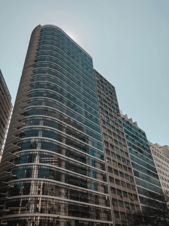 a very tall building with a lot of windows, by Adam Rex, pexels contest winner, panoramic anamorphic, mies van der rohe, exterior, rounded architecture