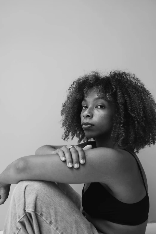 a black and white photo of a woman sitting on a bed, a black and white photo, by Lily Delissa Joseph, pexels contest winner, black arts movement, natural hair, headshot profile picture, sza, sitting down