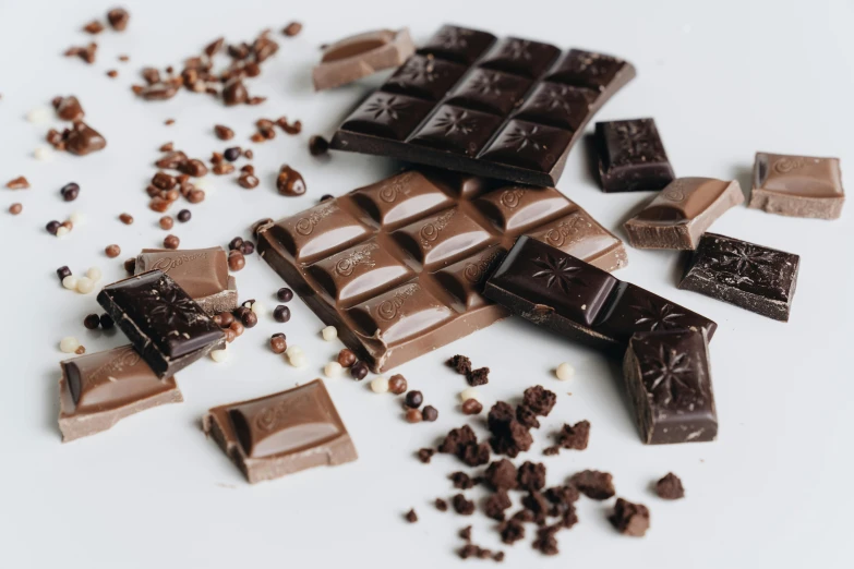 a white plate topped with pieces of chocolate, trending on pexels, chocolate candy bar packaging, different sizes, 6 pack, black