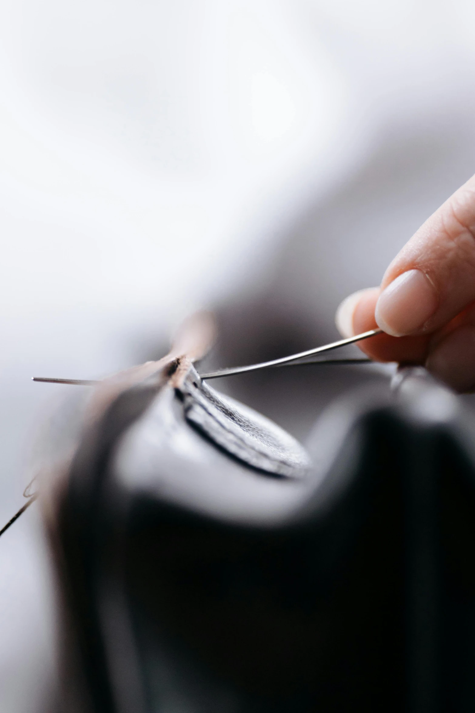 a person cutting a piece of leather with a pair of scissors, detailed intricate hair strands, zoomed in, growing, chiroptera ears