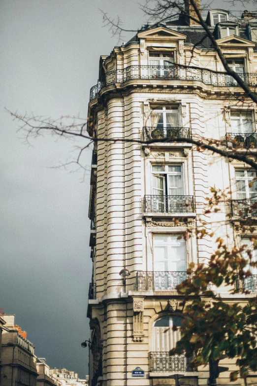 a tall building sitting on the side of a street, a photo, trending on unsplash, paris school, autum, overcast gray skies, ignant, lush surroundings
