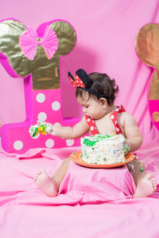 a little girl that is sitting in front of a cake, minnie mouse, colorful backdrop, profile image, poop