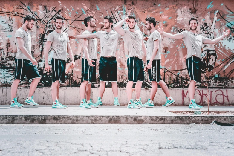 a group of men standing in front of a graffiti covered wall, an album cover, pexels contest winner, happening, basketball, giant legs, teal electricity, portrait!!!