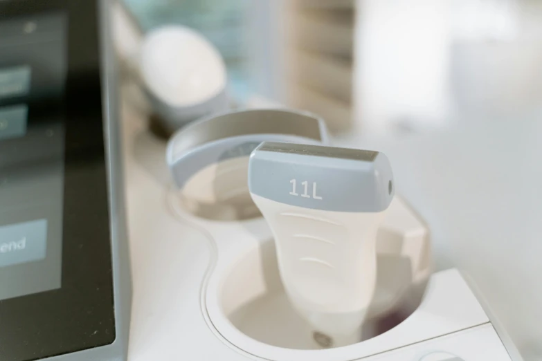 a blender sitting on top of a counter next to a laptop, an engraving, by Emma Andijewska, unsplash, pathology sample test tubes, white and pale blue toned, closeup of arms, speculum